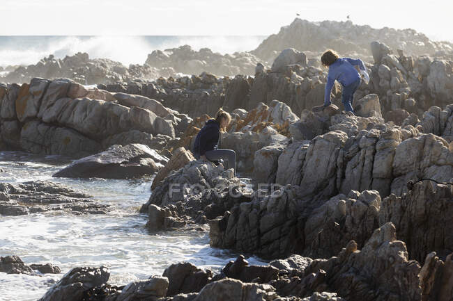 Teenager-Mädchen klettert auf Felsen, De Kelders, Südafrika — Stockfoto