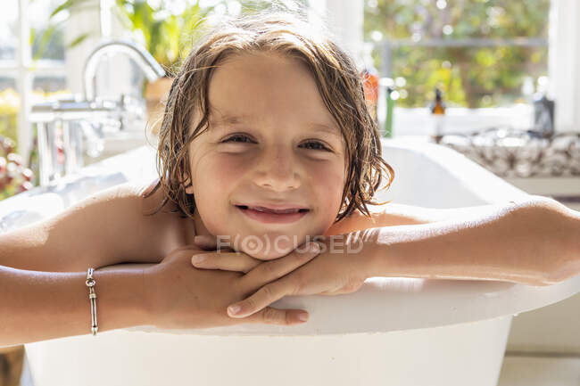 Восьмилетний мальчик в ванной, принимает ванну — стоковое фото
