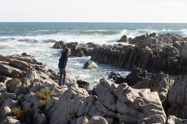 Teenage girl climbing rocks, De Kelders, Sudafrica — Foto stock