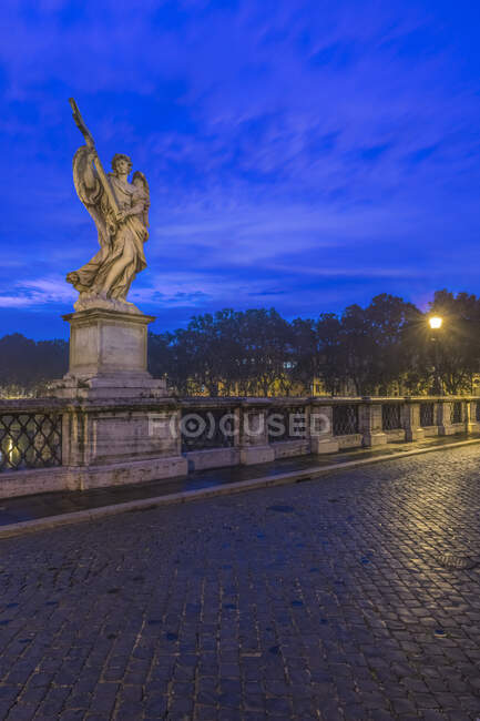 Eine Engelsstatue auf der Brücke Ponte Sant 'Angelo in der Abenddämmerung — Stockfoto