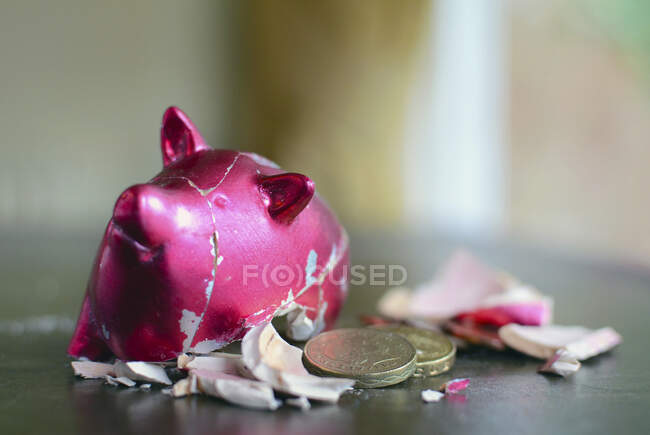 Smashed piggy bank with pounds on table. — Stock Photo