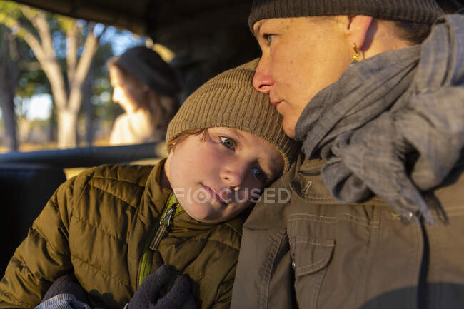 Крупним планом хлопчик і його мати в сафарі джип на ранковому сонці . — стокове фото