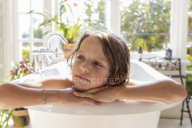 Ragazzo di otto anni nella vasca da bagno, testa e spalle. — Foto stock