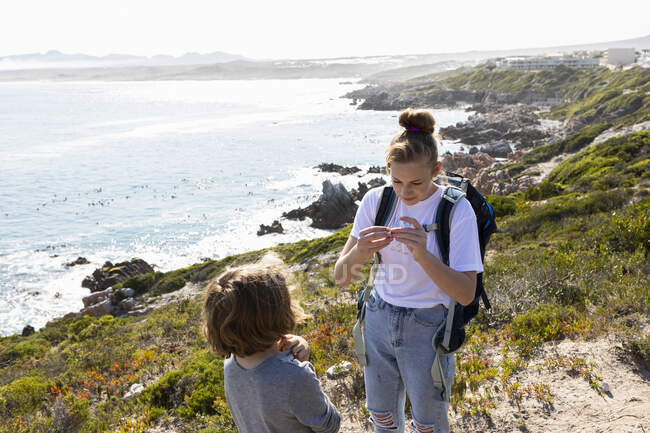 Дівчинка - підліток і молодший брат мандрують береговою стежкою Де - Келдерс (ПАР). — стокове фото