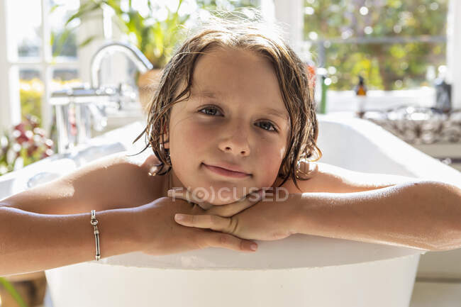 Menino de oito anos na banheira, cabeça e ombros. — Fotografia de Stock