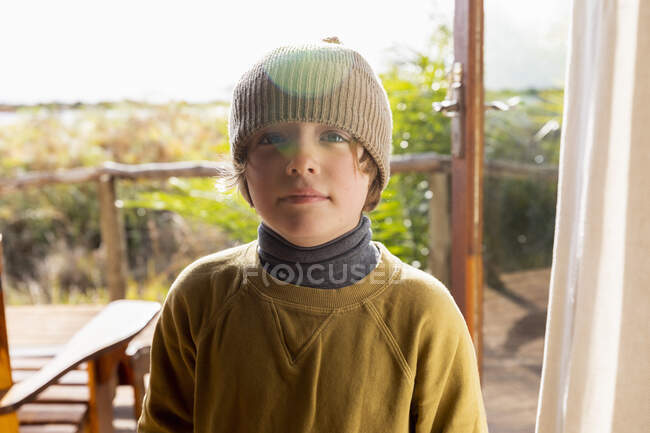 Portrait de jeune garçon avec un chapeau laineux sur une terrasse — Photo de stock