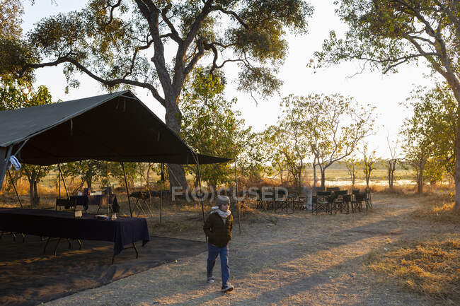 Ein Junge in einem Safaricamp geht mit den Händen in den Taschen — Stockfoto