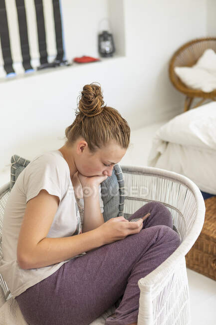 Дівчинка - підліток користується смартфоном у своїй спальні — стокове фото