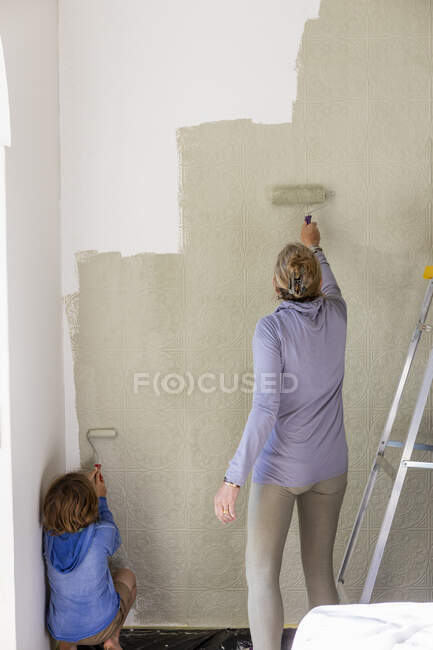 Une femme décorant une pièce, peignant des murs. — Photo de stock
