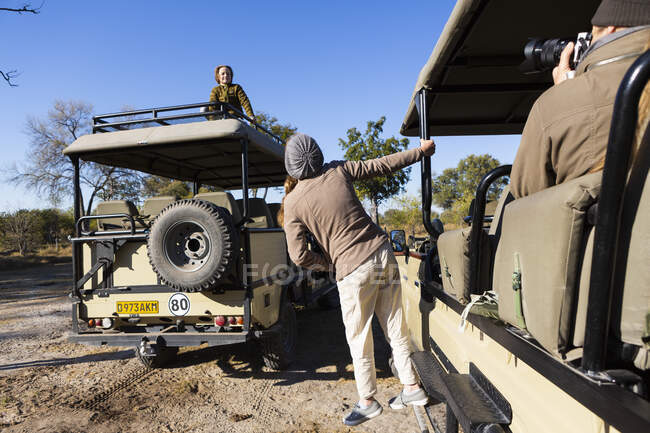 Teenager lehnt sich aus einem Safari-Jeep, ein Junge auf dem Dach eines Fahrzeugs — Stockfoto