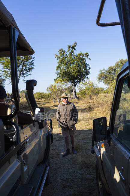 Un guía de safari en un jeep al amanecer conduciendo a través de una reserva de vida silvestre. - foto de stock