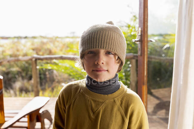 Portrait of young boy in a woolly hat on a terrace — Stock Photo