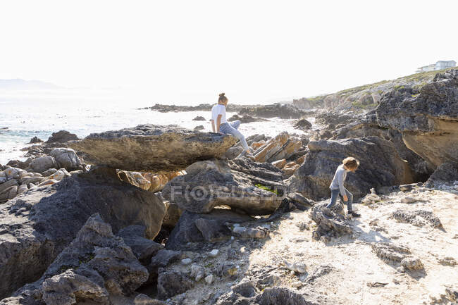 Adolescente e irmão mais novo caminhando em uma trilha costeira junto ao oceano — Fotografia de Stock