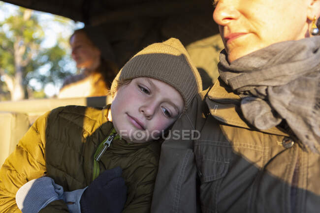 Close up of a boy and his mother in a safari jeep in early morning sun. — Stock Photo