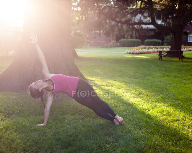 Жінка балансує в позі йоги в парку.. — стокове фото