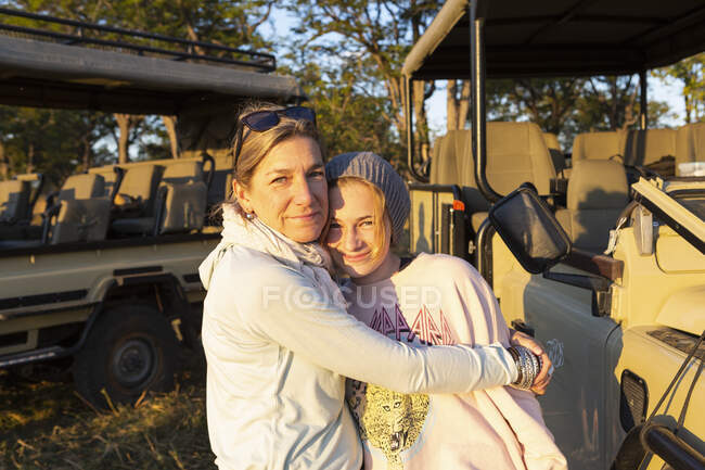 Una madre che abbraccia sua figlia adolescente in una vacanza safari in famiglia. — Foto stock