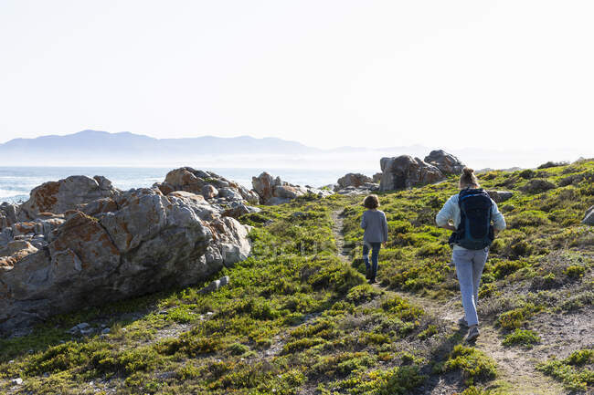 Adolescente e fratello minore escursioni sul sentiero costiero De Kelders, Sud Africa — Foto stock