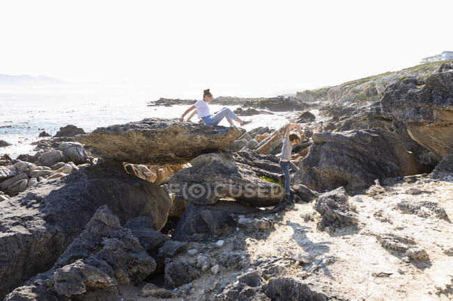 Teenage girl and younger brother hiking on a coastal trail by the ocean — Stock Photo