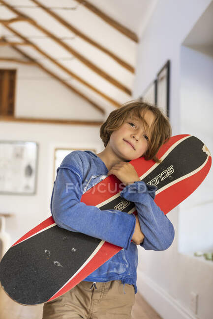 Portrait de garçon de 8 ans avec planche à roulettes — Photo de stock