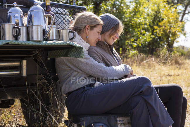 Жінка з донькою - підлітком сидить біля джипу. — стокове фото