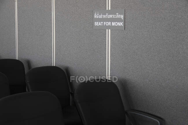 A sign in the waiting area of the airport, Seat reserved for monks. — Stockfoto