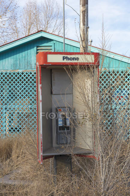 Vieille cabine téléphonique abandonnée et magasin désert au bord de la route. — Photo de stock