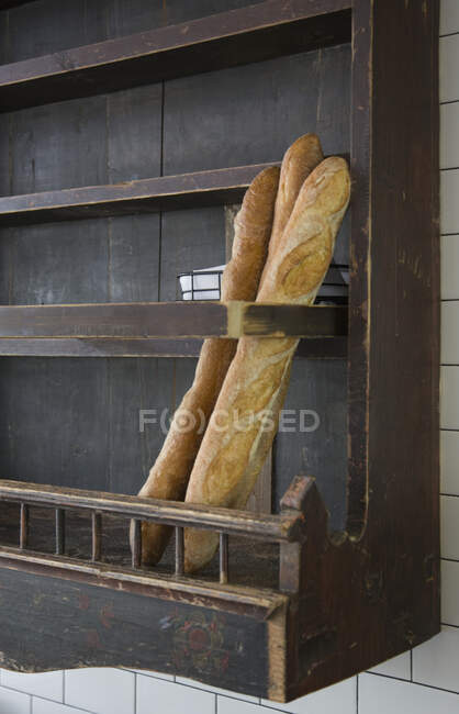 Baguettes in wooden wall rack at a restaurant. — Fotografia de Stock