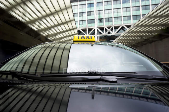 Taxi cab emerging from a garage underneath an office building. - foto de stock
