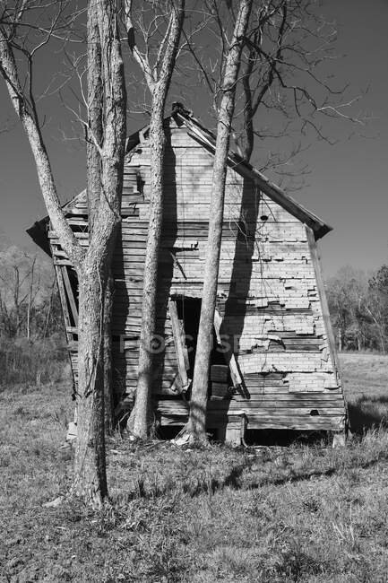 Abandoned homestead wooden building leaning, unstable and collapsing. — Stock Photo