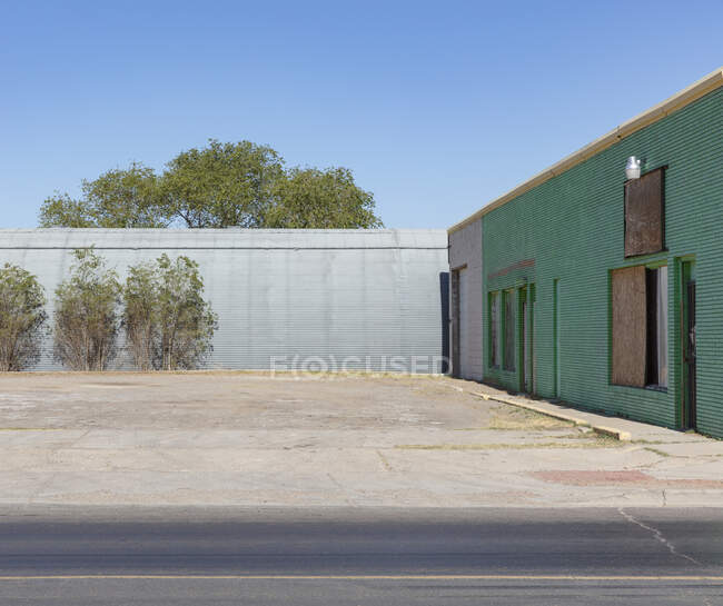 Abandoned warehouse and buildings with plants growing on the walls. — Fotografia de Stock