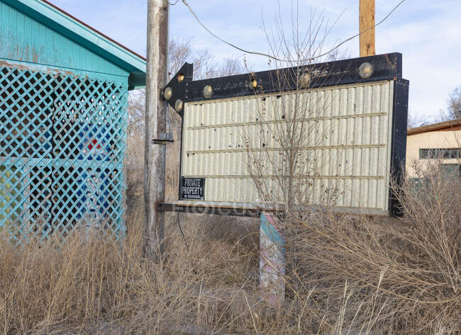 Flèche et panneau vierge devant le magasin en bord de route abandonné. — Photo de stock