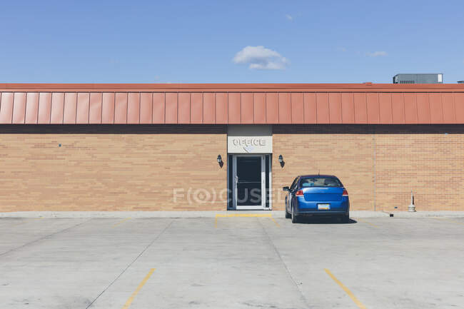 Parked blue car in a parking lot outside a building. — Stock Photo