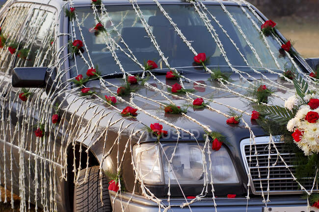 Ein mit roten und weißen Blumen geschmücktes Hochzeitsauto. — Stockfoto