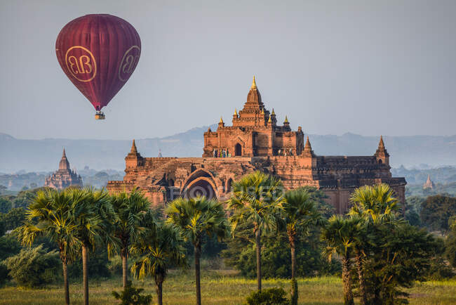 Hot air balloon in the air above a temple in Mandalay. — Stock Photo