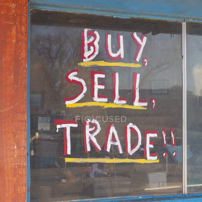 Buy Sell Trade sign in on old storefront window. — Fotografia de Stock