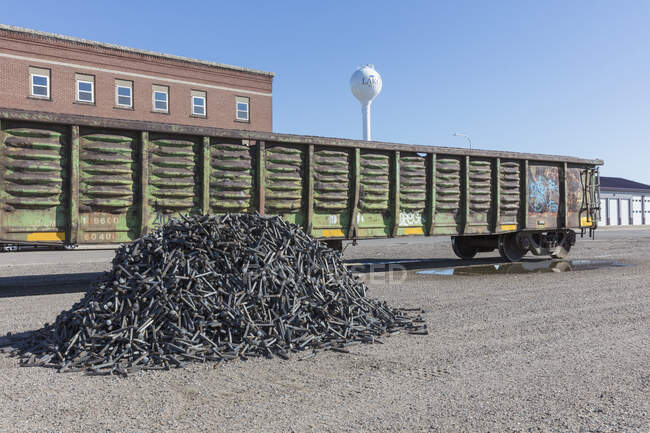 Railroad depot, a boxcar train wagon and a heap of discarded metal pins, track spikes. — Foto stock