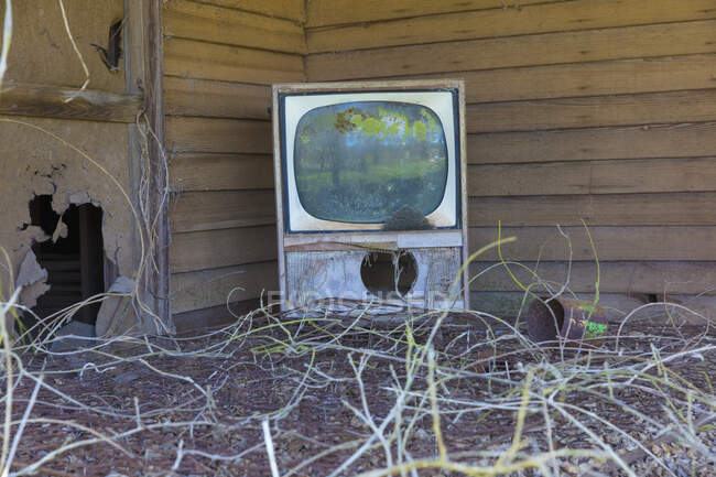 Old TV set on front porch of an abandoned homestead. — Fotografia de Stock