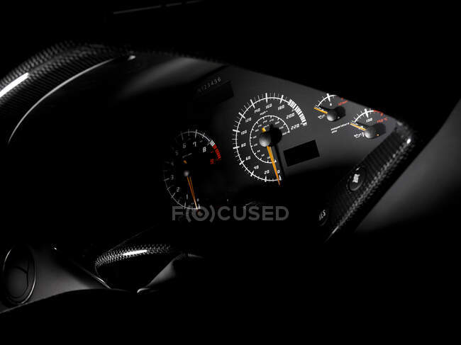 El tablero de instrumentos y la pantalla, un velocímetro, cuentakilómetros de un coche deportivo. - foto de stock