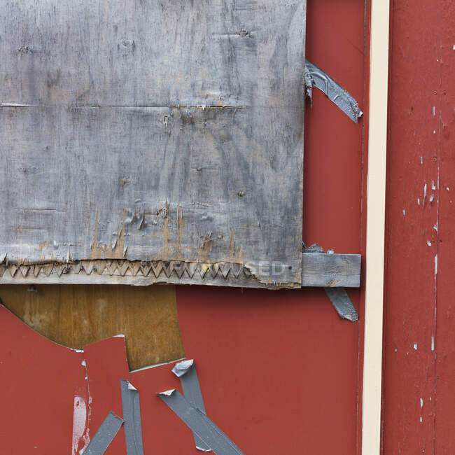 Detail of plywood and duct tape covering the window of an abandoned building — Stock Photo