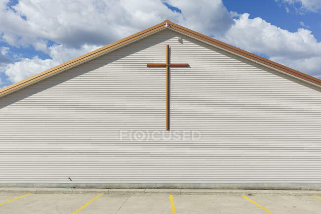 A large cross on the exterior wall of a church in a small town. — Stock Photo