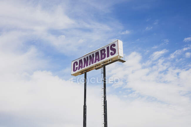 Cannabis sign high above a road. — Stock Photo