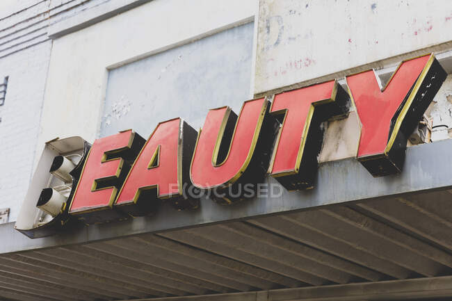Old BEAUTY sign in front of abandoned department store, red lettering. — Stock Photo