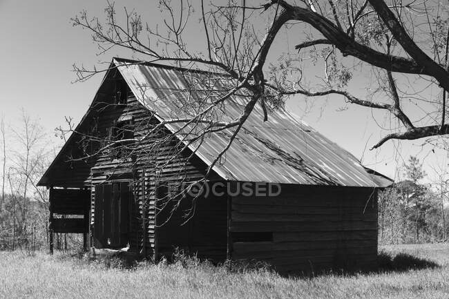 Брошенный амбар, пустой и разрушенный, черно-белый образ. — стоковое фото