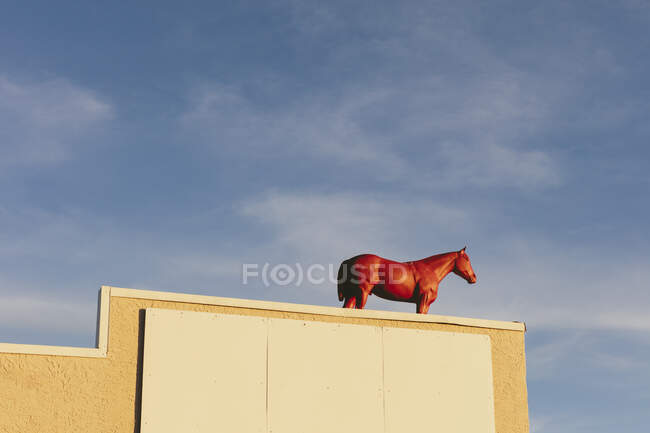 Painted red horse on building rooftop, — Fotografia de Stock