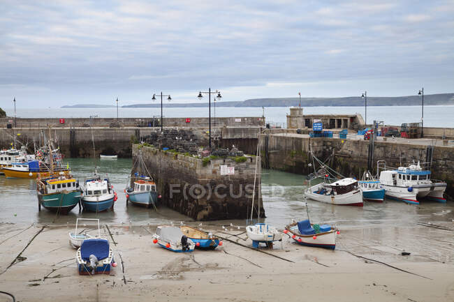 Low tide at a Cornish harbour, sea coast fishing village, boats moored, beached on the sand. — Stock Photo