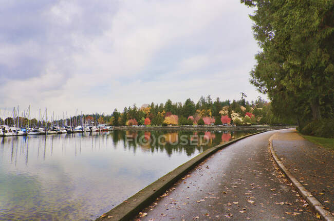 Stanley park in autumn,  pathway along the waterfront, marina and woodland. — Stock Photo