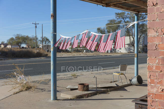 American flags in front of abandoned gas station. — Fotografia de Stock