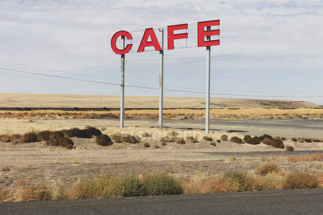 Large CAFE sign over rural farmland. - foto de stock