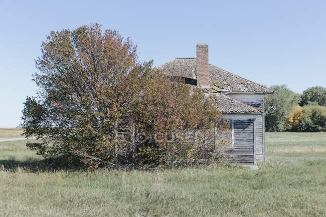 One room school house building by a road on the prairie. — Photo de stock