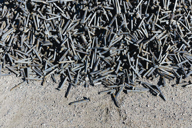 Railroad depot, a heap of discarded metal pins, track spikes used on the railroad track. - foto de stock